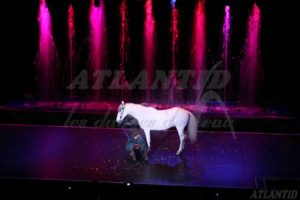 Atlantid - Spectacle avec un cheval sur scène et des jets d'eau roses en arrière plan