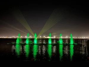 Lors d'un spectacle aquatique au Portugal, des fontaines dansantes vertes accompagnés d'un laser projetant des faisceaux jaunes